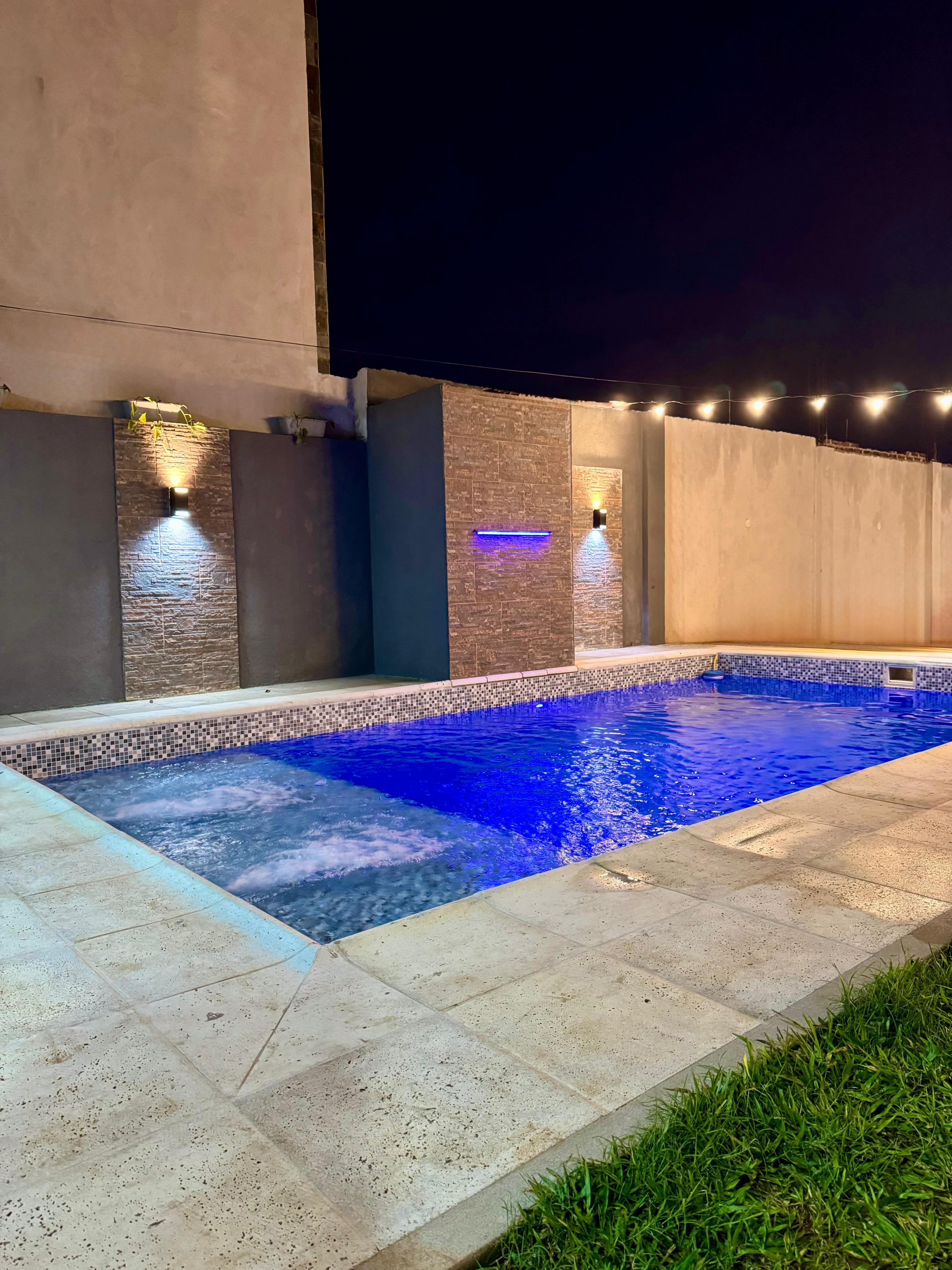 Quincho moderno con piscina iluminada